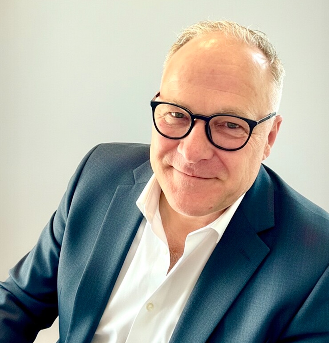 Friedhelm Fischer mit Brille, dunklem Sakko und weißem Hemd